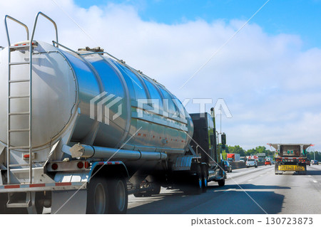 Heavy truck with large tanker is traveling on busy American highway under driving day 130723873