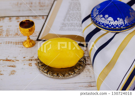1 August 2025 Jerusalem Israel Traditional etrog citrus fruit, ceremonial cup, kippah on tallit prayer shawl during Jewish holidays Sukkot festival traditions Tanakh prayer holy book 130724018