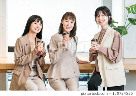 Businessman and businesswoman chatting over coffee in the office 130724530