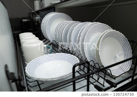 Clean Dishes Neatly Arranged in a Dishwasher After a Family Meal in a Modern Kitchen 130724730