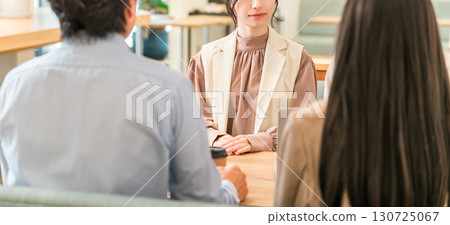 Businessmen and businesswomen discussing business at a table in a business meeting space Businessmen and businesswomen discussing business at a table in a business meeting space 130725067