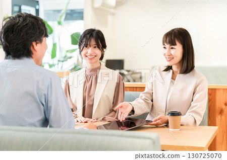 Businessmen and businesswomen discussing business at a table in a business meeting space 130725070