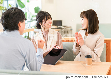 Businessmen and businesswomen discussing business at a table in a business meeting space 130725071