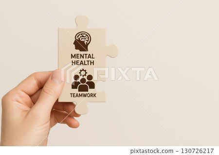 Mental health teamwork concept with hand holding puzzle piece showing brain icon and people symbol, representing support, cooperation, and wellness in business environment Mental health teamwork concept with hand holding puzzle piece showing brain icon and people symbol, representing support, cooperation, and wellness in business environment 130726217