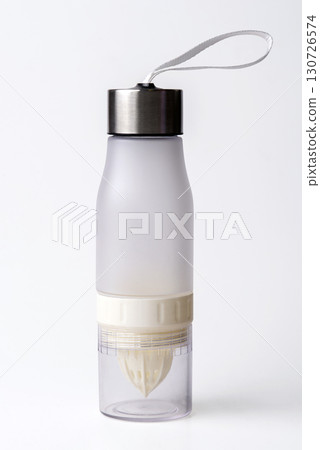A plastic fruit infuser water bottle with a built-in citrus juicer and a metal cap, isolated on a white background. 130726574