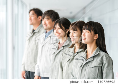 Male and female staff in the manufacturing, building, transportation, and construction industries wearing work clothes. 130726698