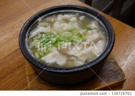 Samgyetang, a hearty Korean ginseng chicken soup, featuring a whole young chicken stuffed with rice, garlic, jujube, and herbs. A nourishing dish perfect for health and comfort. 130726762