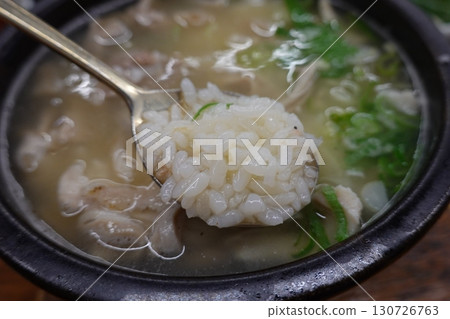 Samgyetang, a hearty Korean ginseng chicken soup, featuring a whole young chicken stuffed with rice, garlic, jujube, and herbs. A nourishing dish perfect for health and comfort. 130726763