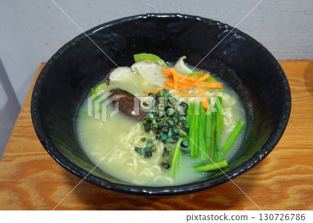 A steaming bowl of ramen with rich broth, tender noodles, sliced pork, boiled egg, nori, and fresh green onions. A comforting and flavorful Japanese classic. A steaming bowl of ramen with rich broth, tender noodles, sliced pork, boiled egg, nori, and fresh green onions. A comforting and flavorful Japanese classic. 130726786