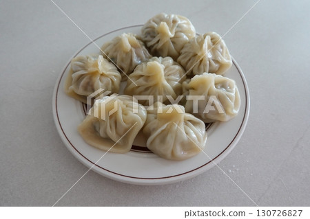 Korean dumplings filled with a mix of savory ingredients like ground meat, tofu, and vegetables. Mandu can be steamed, boiled, or pan-fried, making it a versatile and delicious snack or meal. 130726827