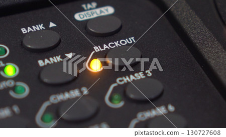 Man activates Blackout mode: close-up of button press on lighting console with blinking LED. 4K 130727608