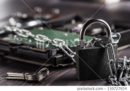The hard drive is wrapped in metal chains, symbolizing reliable data protection 130727654