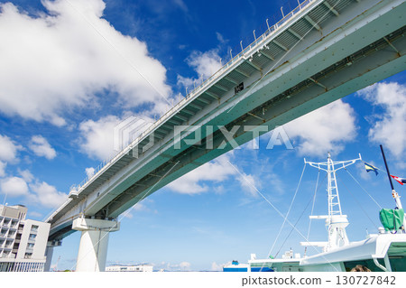 A view of Naha Tomari Port from a departing ship. Tomari Bridge and Tomarin are visible. Naha Tomari Port, Naha City, Okinawa Prefecture - June 26, 2025 130727842