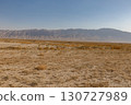 Arid desert landscape of Balkh Province in Afghanistan with a vast mountain range behind 130727989