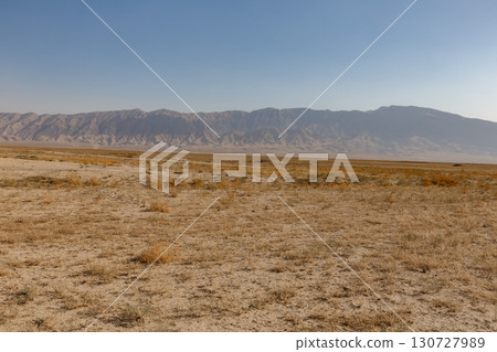 Arid desert landscape of Balkh Province in Afghanistan with a vast mountain range behind Arid desert landscape of Balkh Province in Afghanistan with a vast mountain range behind 130727989