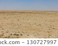 Vast desert landscape of Jowzjan Province, Afghanistan with sparse vegetation under a hazy sky 130727997