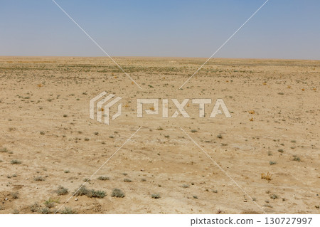 Vast desert landscape of Jowzjan Province, Afghanistan with sparse vegetation under a hazy sky Vast desert landscape of Jowzjan Province, Afghanistan with sparse vegetation under a hazy sky 130727997