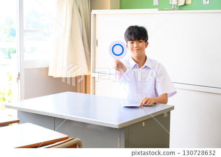 Male student answering a quiz in a school classroom. A learning scene where students answer with true or false questions. 130728632
