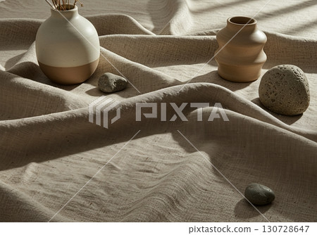 Natural Linen Textile Flatlay with Ceramic Vessel, Organic Wood Elements, and Stone Objects for Eco Branding 130728647