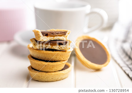Sweet chocolate tartelettes on white table. 130728954