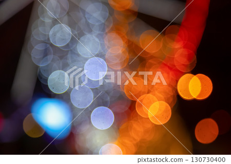 A magical bokeh pattern of golden and colorful lights on a dark background 130730400