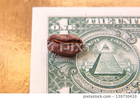 split coffee bean lies on a U.S. one-dollar bill, blending earthy brown with the bill split coffee bean lies on a U.S. one-dollar bill, blending earthy brown with the bill 130730410