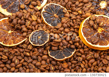 A textured display of dried orange slices resting on roasted coffee beans 130730421