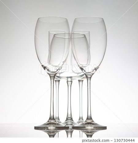 Five stylish wine glasses with unique contours, their reflections mirrored 130730444