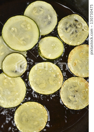 Zucchini slices frying in hot oil Zucchini slices frying in hot oil 130730475