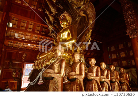 Golden sitting Buddha statue and there is a serpent covering the back in Buddhist Thai Church at Wat Den Sali Si Mueang Kaen temple. Located at Chiang Mai city in Thailand. Golden sitting Buddha statue and there is a serpent covering the back in Buddhist Thai Church at Wat Den Sali Si Mueang Kaen temple. Located at Chiang Mai city in Thailand. 130730620