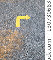 Faded Yellow Directional Arrow on Gravel. 130730683
