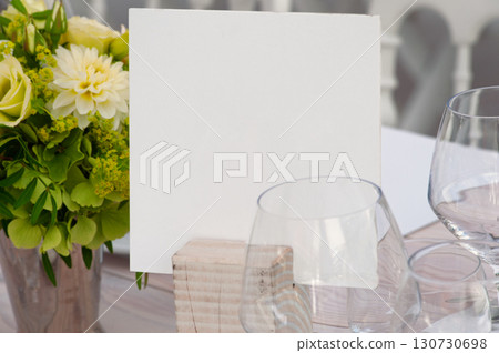Elegant Table Setting with Blank Card and Flower Arrangement 130730698