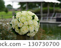 Elegant White Rose Bouquet on Wooden Post by a Tranquil Pond 130730700