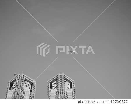 A clear sky with an airplane passing over the Tokyo Metropolitan Government Building 130730772