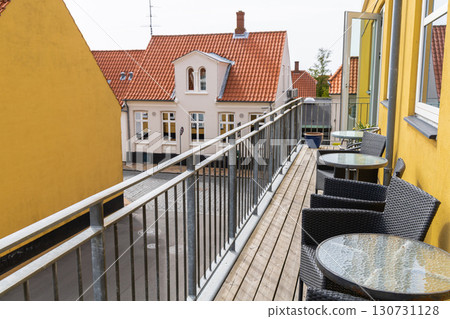 A large veranda or balcony with chairs and tables for relaxing on a summer day. 130731128