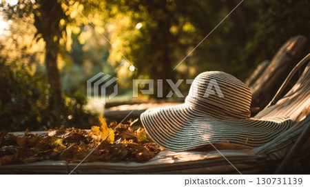 Striped summer hat resting on a sun lounger in a garden 130731139