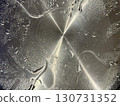 Wet stainless steel surface with scattered water droplets in artistic lighting, modern texture, kitchen appliance detail, cleanliness, and abstract metal background 130731352