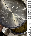 Closeup of wet stainless steel pot lid with water droplets and condensation, kitchen cookware texture, modern cooking, appliance detail, and household culinary background 130731355
