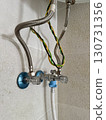 Closeup of chrome bathroom plumbing valves, braided steel pipes, and twisted safety cables, water heater installation, modern utility, maintenance, and home infrastructure concept 130731356
