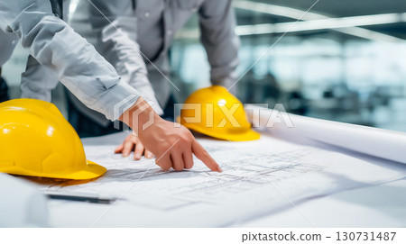 Construction team brainstorming around construction plans 130731487