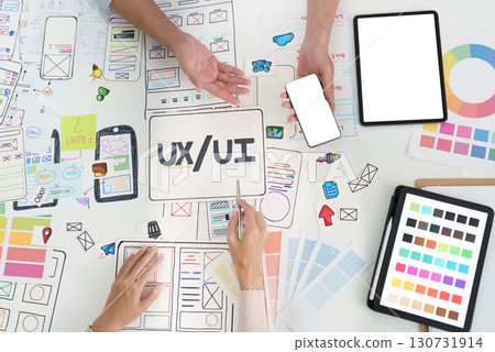UXUI design collaboration with devices and sketches on table 130731914