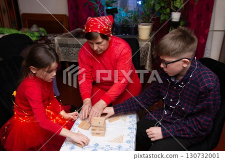 Generations connect over a game of blocks, sharing laughter and creating lasting memories. 130732001