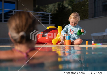Mother and baby in outdoor swimming pool of tropical resort. Mother and baby in outdoor swimming pool of tropical resort. 130732260