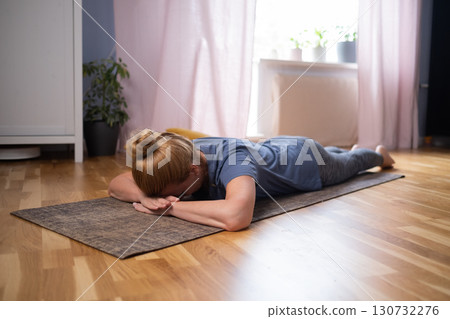 Mature caucasian woman resting after yoga practice in savasana Mature caucasian woman resting after yoga practice in savasana 130732276
