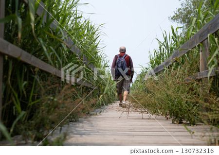 elderly man walking on tourist trail in nature reserve, Portugal 130732316