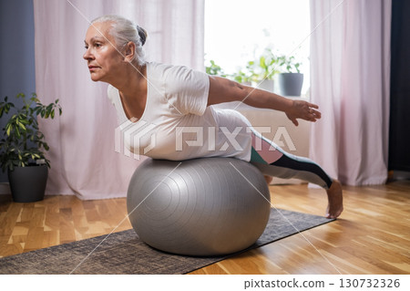 Middle aged woman in plank position keeps fit in her home Middle aged woman in plank position keeps fit in her home 130732326