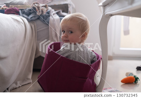 toddler girl playing in a box in the living room toddler girl playing in a box in the living room 130732345