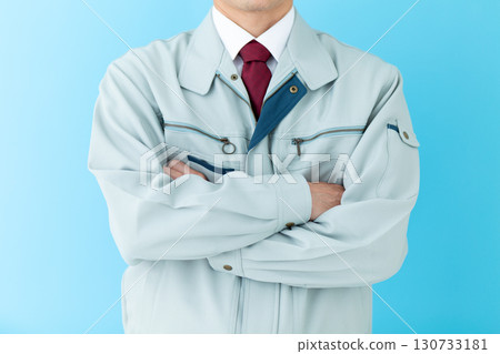 A middle-aged male businessman in work clothes with his arms folded 130733181
