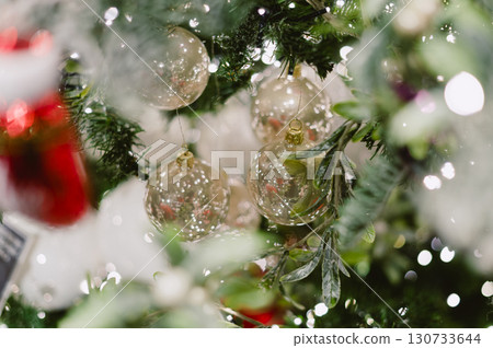 A tree with a bunch of Christmas ornaments hanging from it 130733644