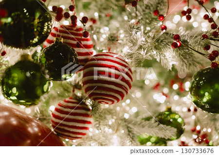 A christmas tree with a red and white striped ornament and a santa 130733676